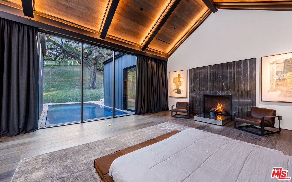 24350 Bridle Trail Road Hidden Hills, CA 91302 - Photo 15 of 23 a living room with a fireplace furniture and a large window