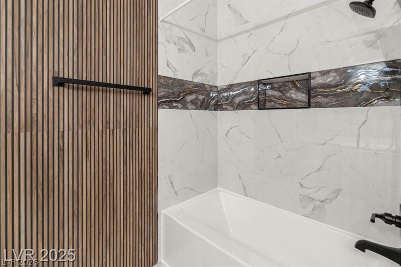 3320 South Fort Apache Road, Unit 125 Las Vegas, NV 89117 - Photo 15 of 26 Clean lines define this bathroom, featuring a deep soaking tub and stylish marble-patterned tile accents.