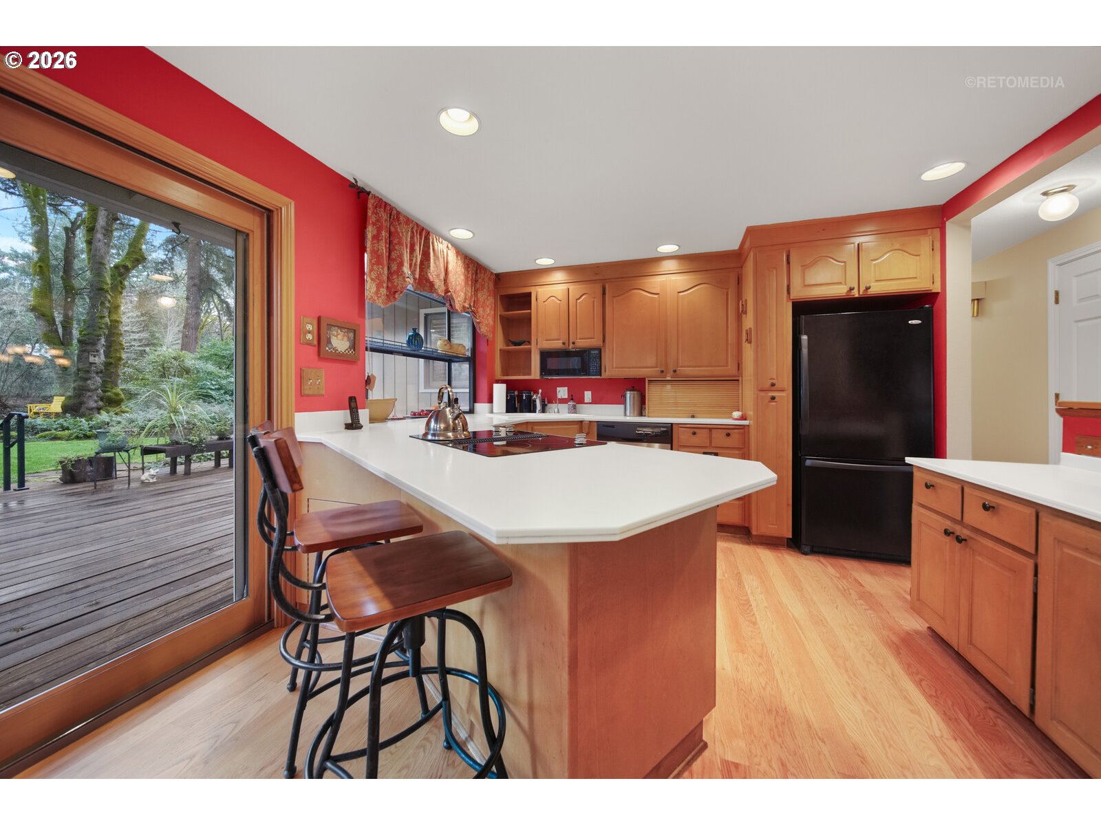 17738 Kelok Road Lake Oswego, OR 97034 - Photo 10 of 48 a kitchen with stainless steel appliances kitchen island granite countertop a refrigerator a stove a sink dishwasher with a dining table and chairs with wooden floor