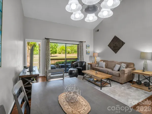 a living room with furniture a floor to ceiling window and a flat screen tv