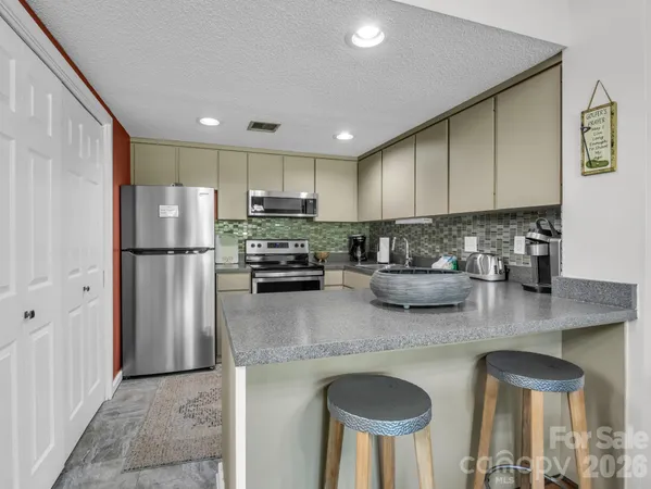 a kitchen with stainless steel appliances granite countertop a sink refrigerator and microwave