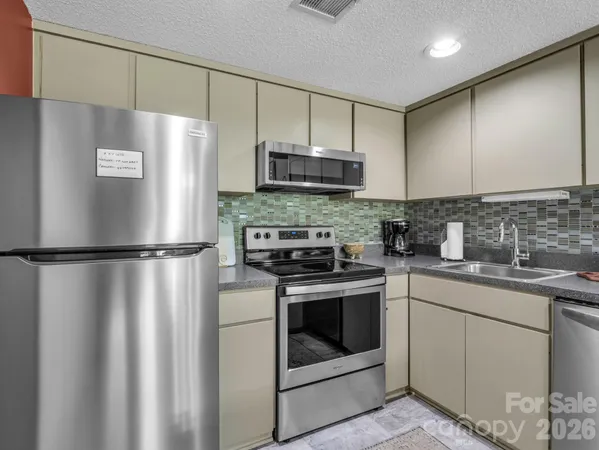 a kitchen with stainless steel appliances a refrigerator sink and microwave