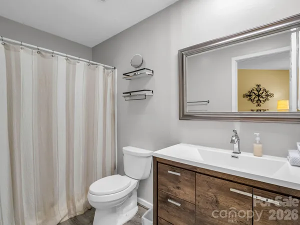 a bathroom with a sink a toilet and a mirror