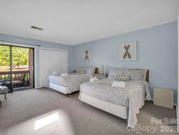 a spacious bedroom with a bed and glass window