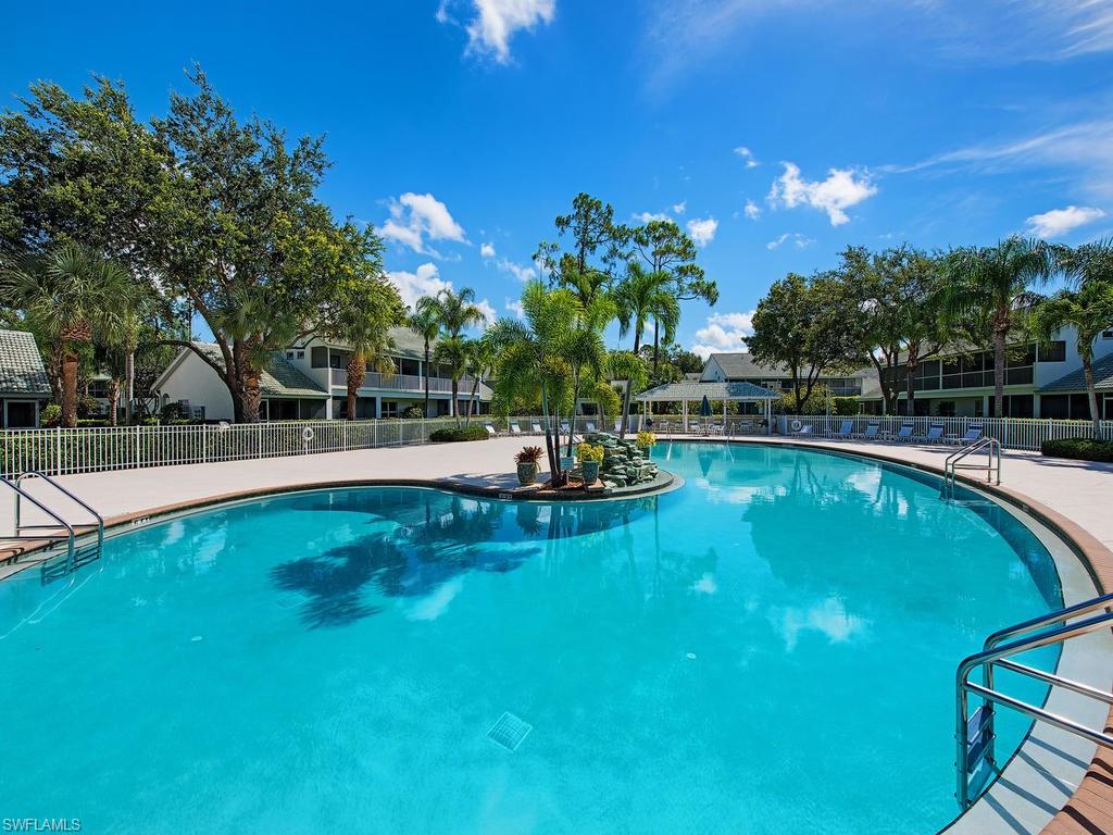 1095 Partridge Circle, Unit 201 Naples, FL 34104 - Photo 12 of 12 a swimming pool with outdoor seating and yard