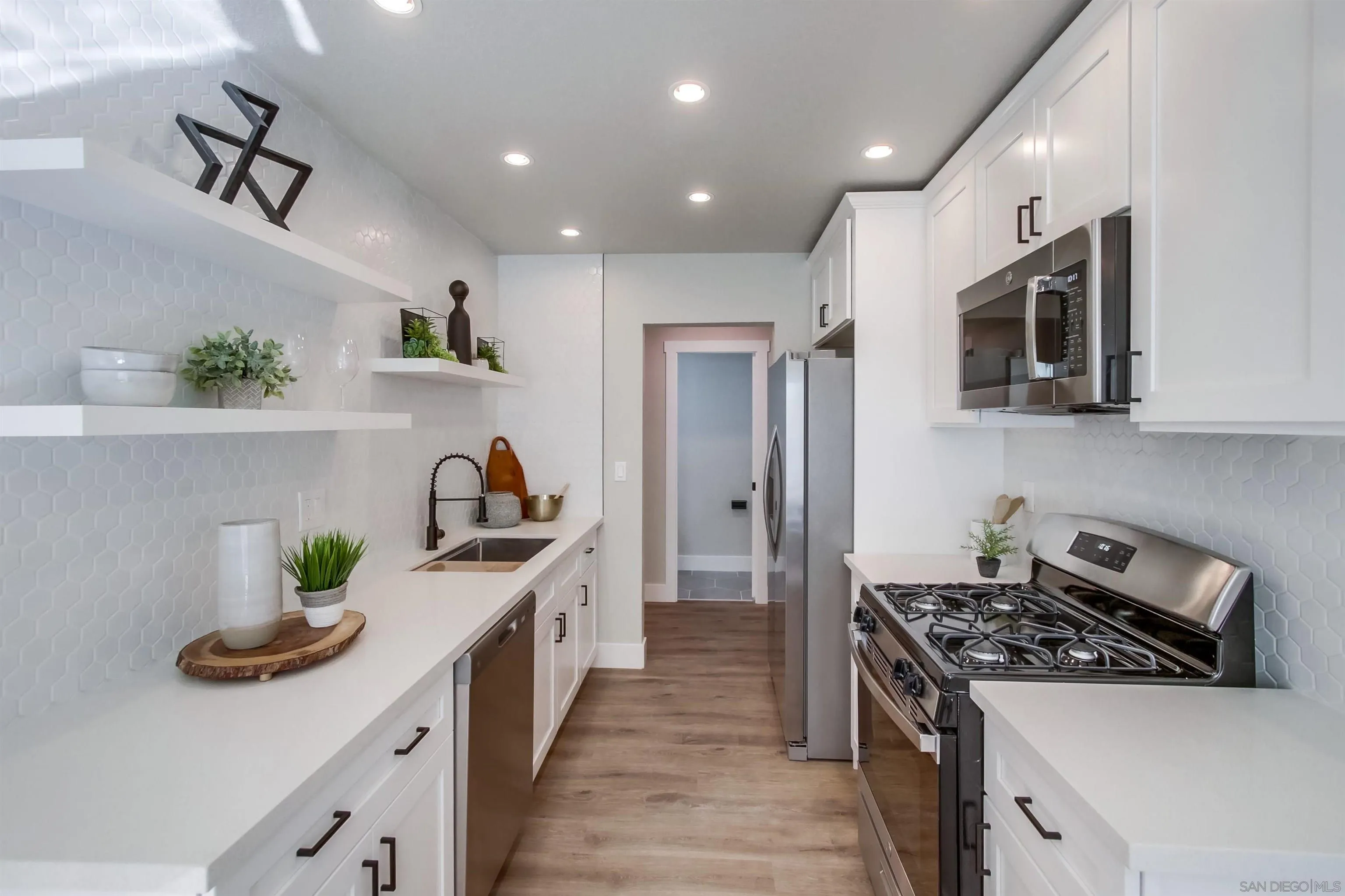a kitchen with kitchen island stainless steel appliances a sink a stove and cabinets