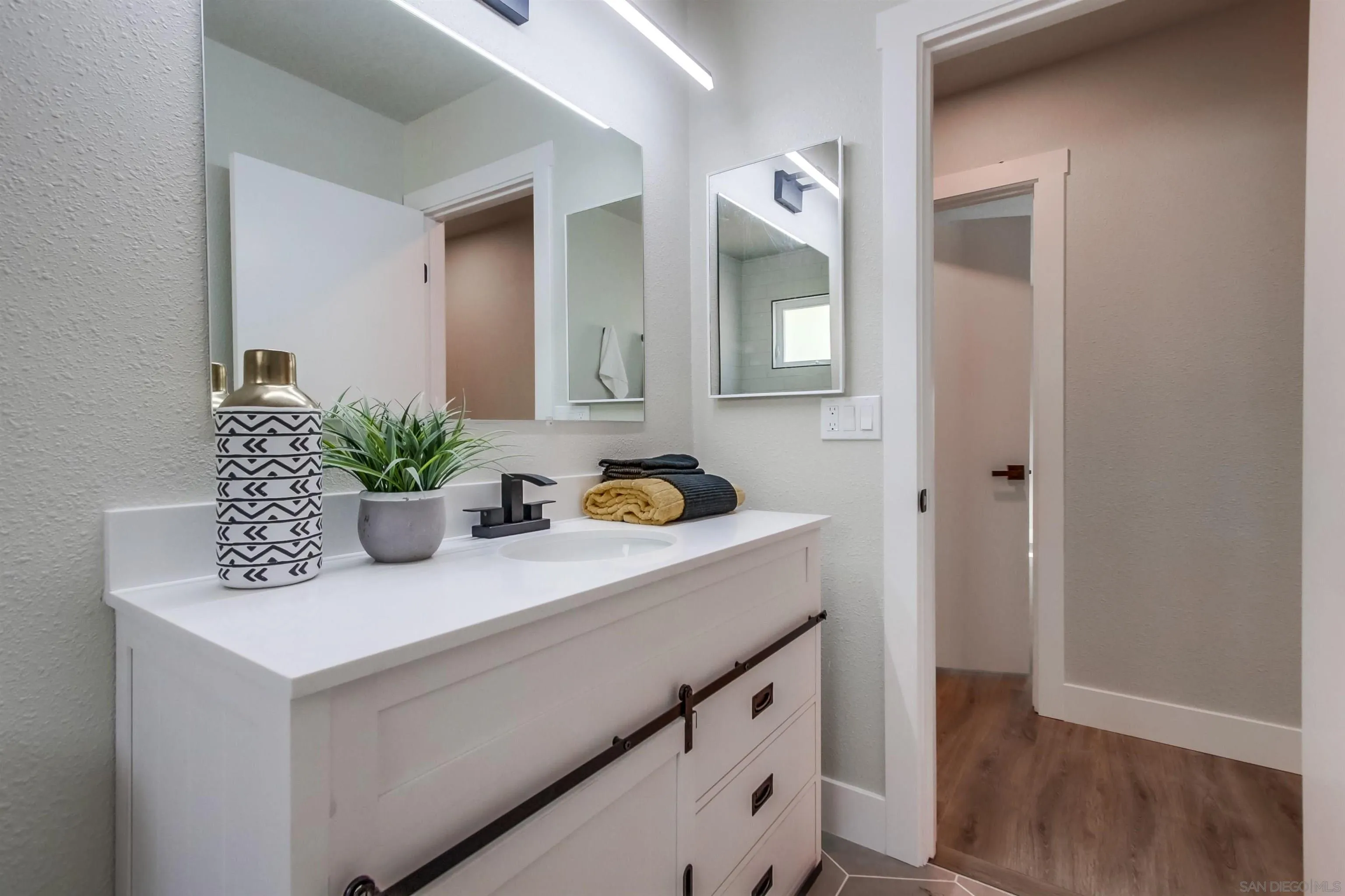 238 69th Street San Diego, CA 92114 - Photo 16 of 27 a bathroom with a sink and a mirror