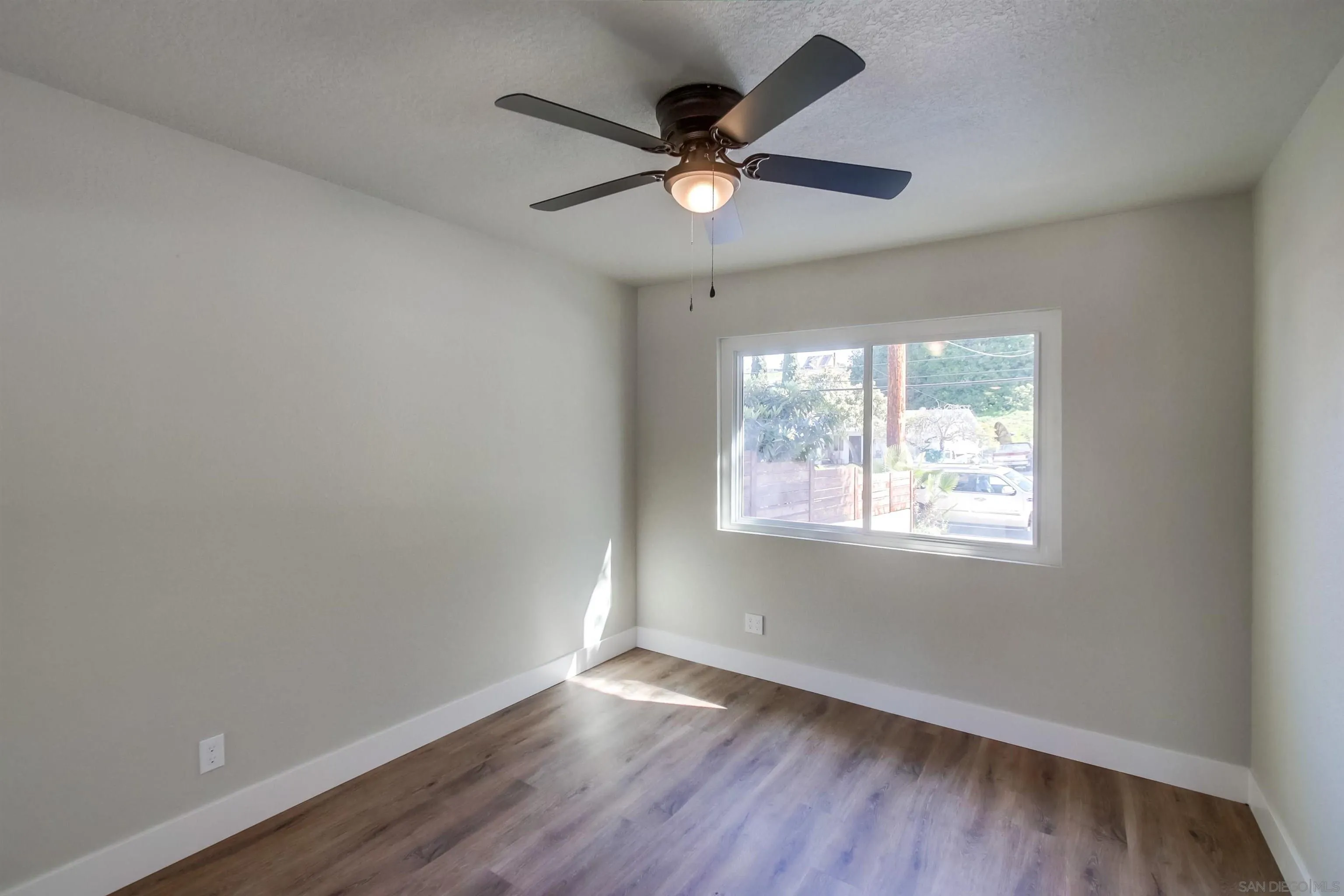 238 69th Street San Diego, CA 92114 - Photo 21 of 27 an empty room with wooden floor fan and windows