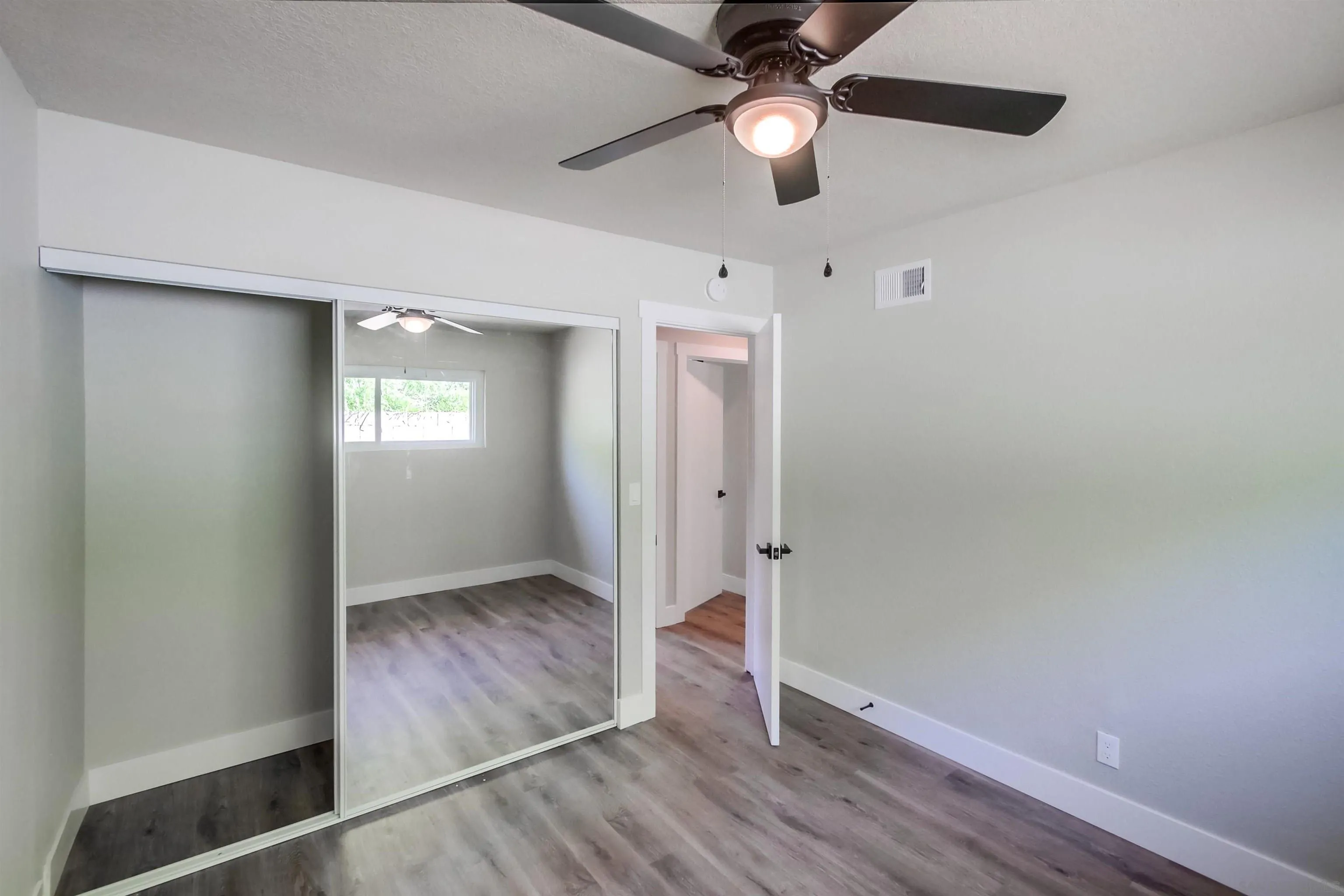 238 69th Street San Diego, CA 92114 - Photo 26 of 27 an empty room with wooden floor fan and windows
