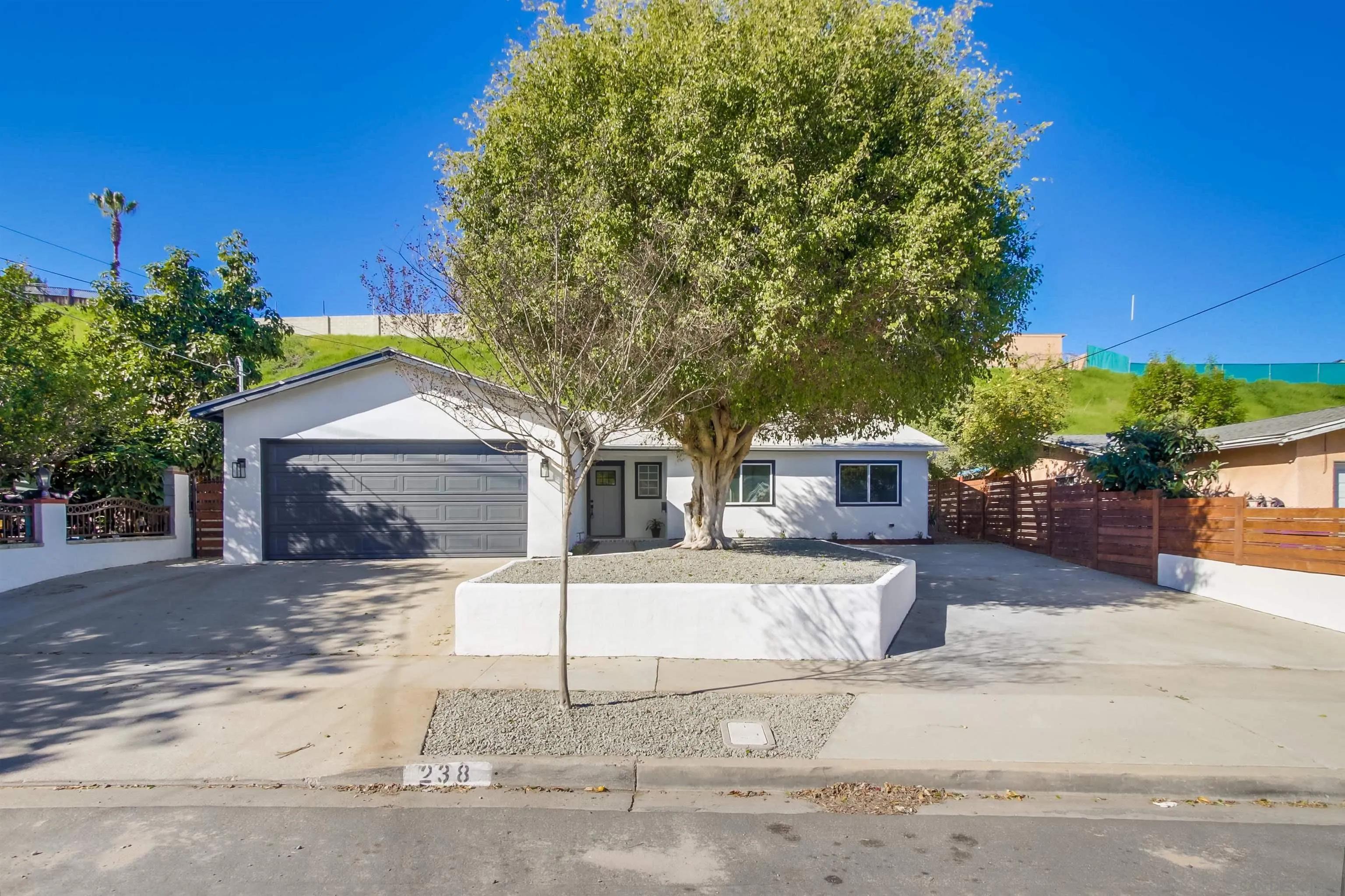 238 69th Street San Diego, CA 92114 - Photo 5 of 27 a front view of a house with a yard and garage