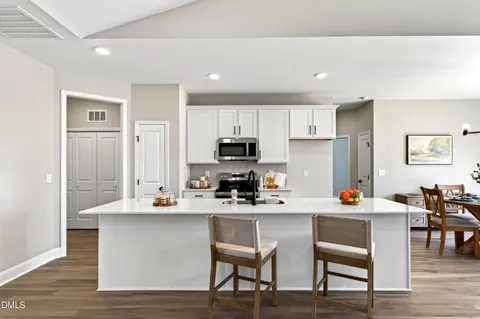 a kitchen that has a lot of cabinets a sink and appliances in it
