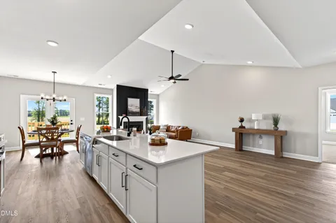 a kitchen with stainless steel appliances granite countertop a sink dishwasher stove and microwave with wooden floor