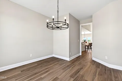 a view of empty room with wooden floor and window