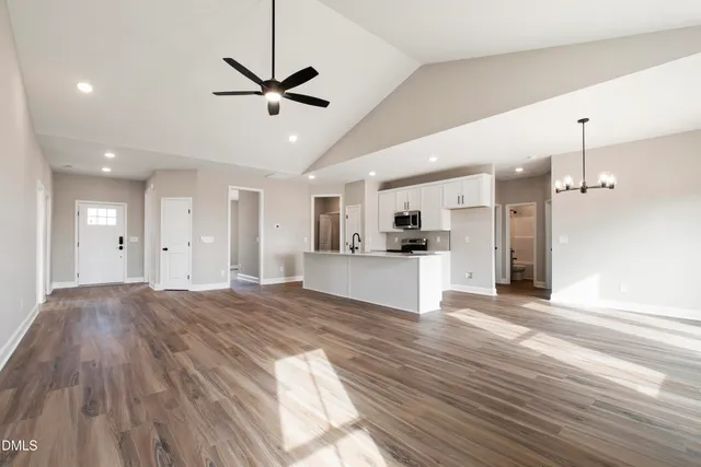 a view of an empty room and kitchen view
