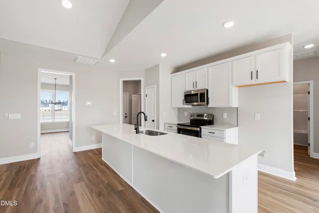a kitchen with counter top space wooden floor and stainless steel appliances