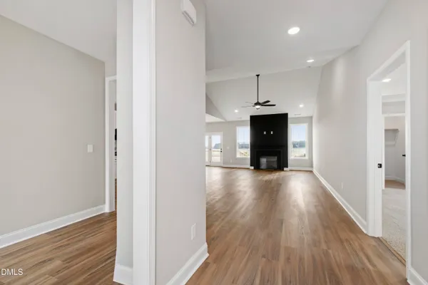 a view of a hallway with wooden floor and a fireplace