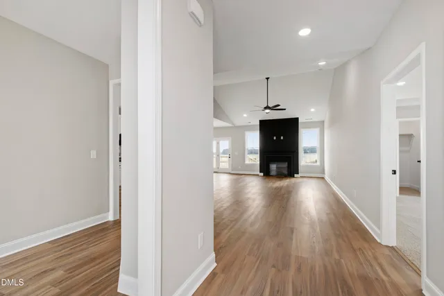 a view of a hallway with wooden floor and a fireplace