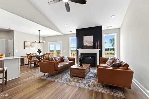 a living room with furniture a fireplace and kitchen view