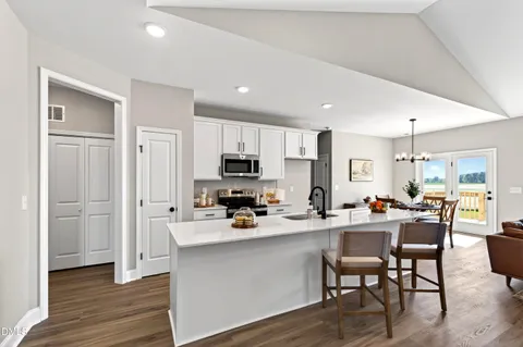 a kitchen with a sink a stove a refrigerator cabinets and wooden floor