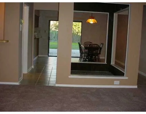 a view of a hallway with wooden floor and living room