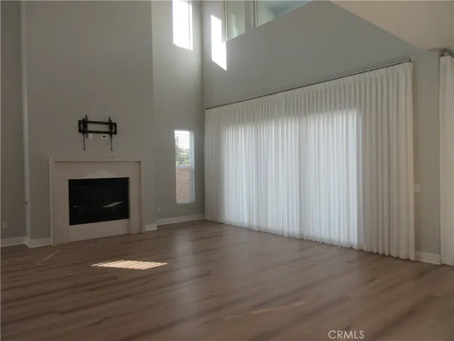 a view of a livingroom with wooden floor a fireplace and window