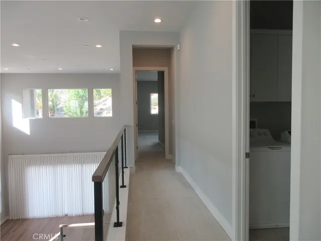 a view of hallway with a window and wooden floor