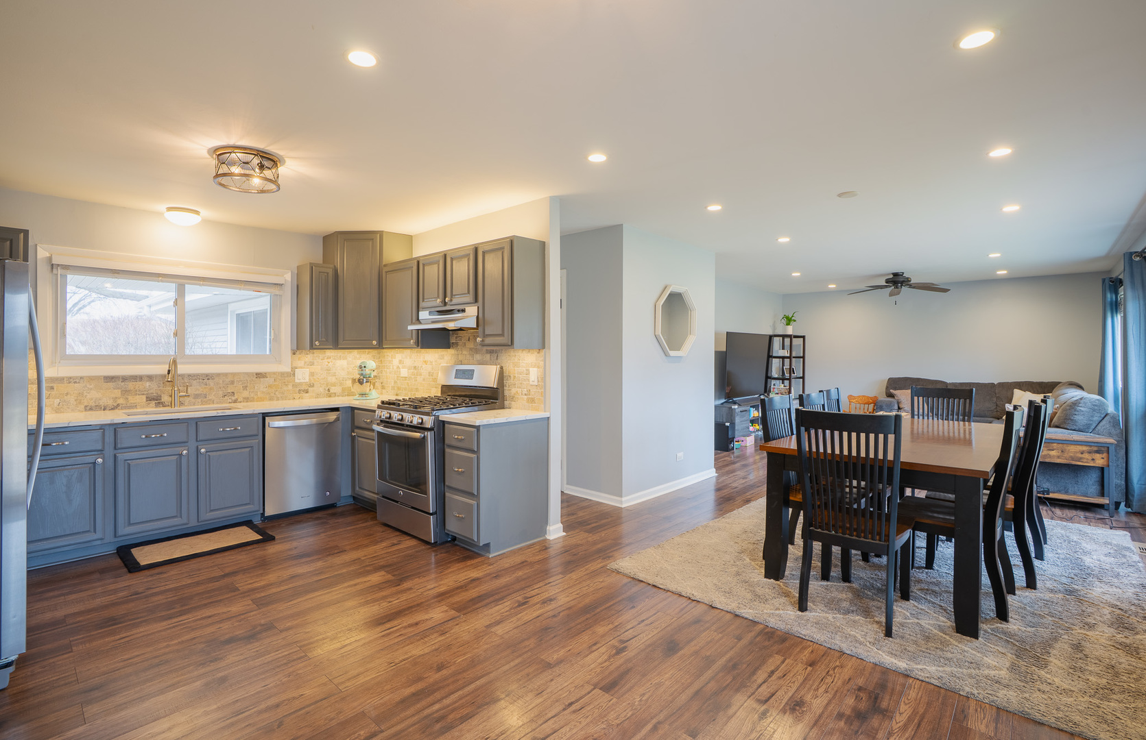 1935 Larchmont Road Hoffman Estates, IL 60169 - Photo 12 of 30 a kitchen with stainless steel appliances kitchen island granite countertop wooden floors and wooden cabinets