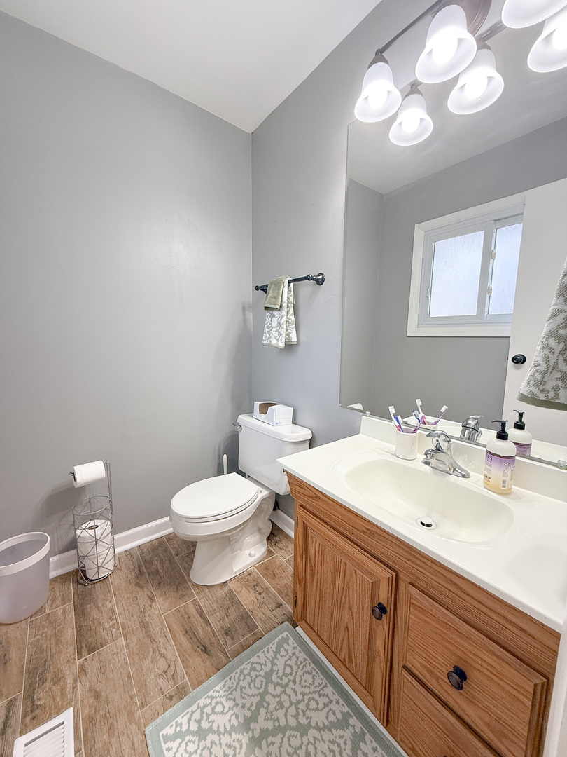 1935 Larchmont Road Hoffman Estates, IL 60169 - Photo 22 of 30 a bathroom with a sink a toilet and a mirror