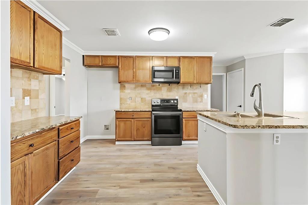 2923 Glendale Drive Wylie, TX 75098 - Photo 2 of 13 a kitchen with stainless steel appliances granite countertop a stove a sink and a refrigerator