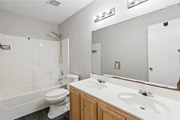 a bathroom with a toilet a sink a mirror a bathtub and vanity