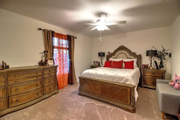a bedroom with a bed and a flat tv screen on dresser