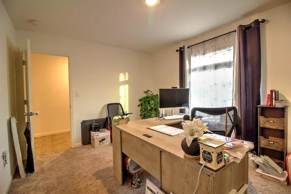a view of a workspace with furniture and a window