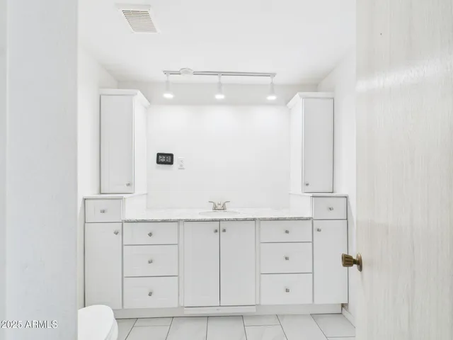 a bathroom with a sink vanity and mirror