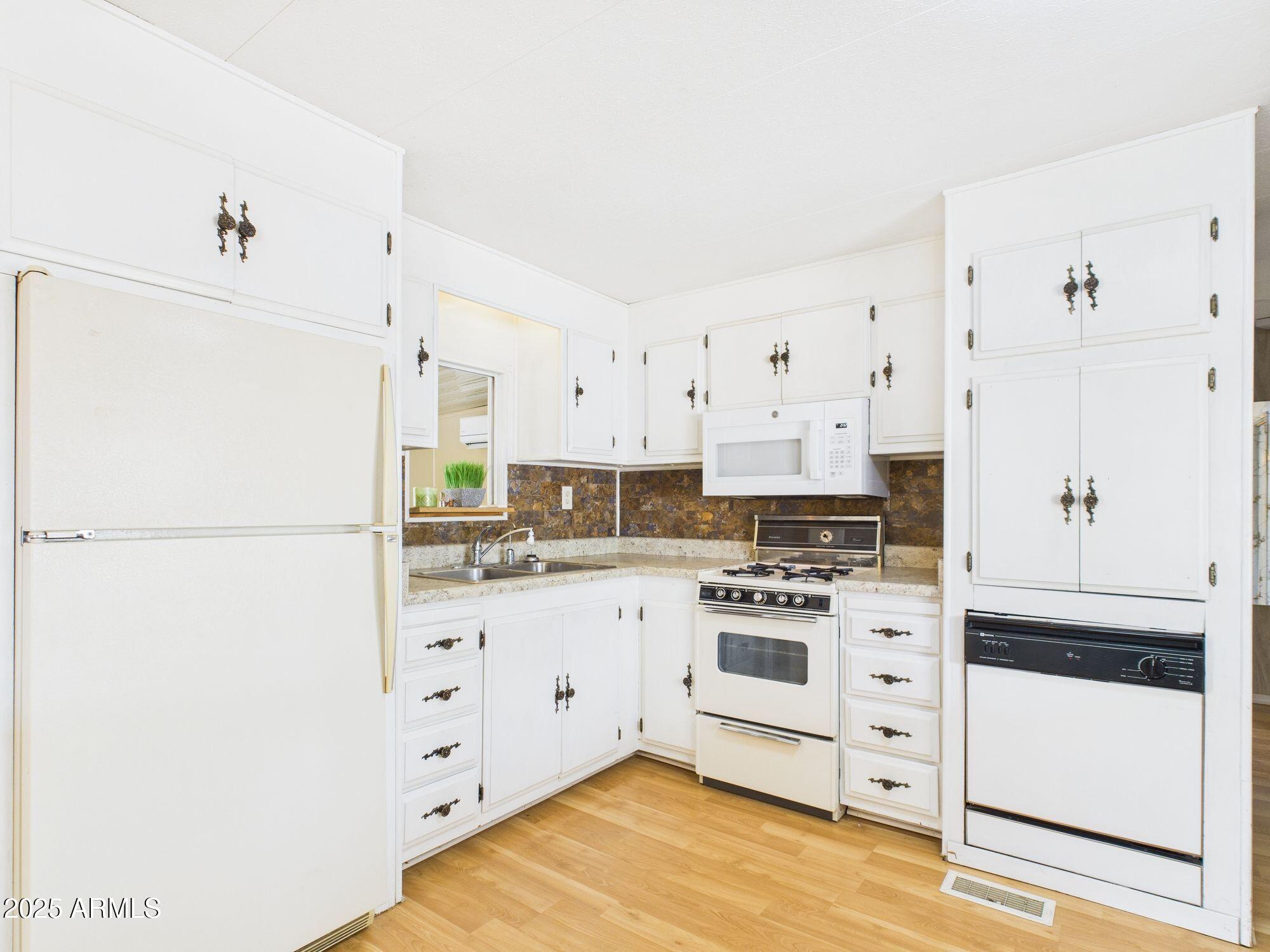 428 South 80th Way Mesa, AZ 85208 - Photo 8 of 21 a kitchen with stainless steel appliances a stove a refrigerator and white cabinets