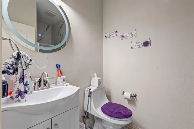 a bathroom with a sink mirror vanity and toilet