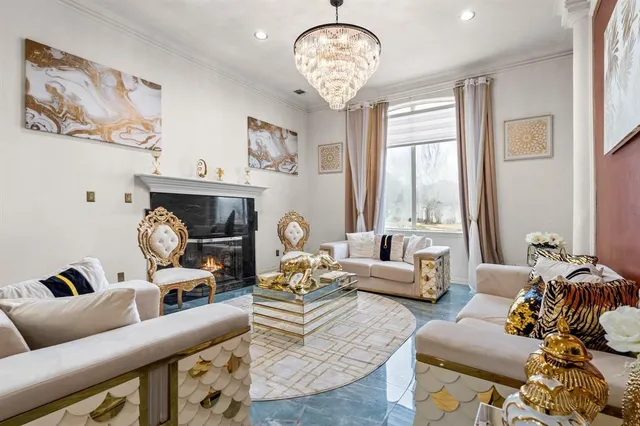 a living room with furniture chandelier and a large window