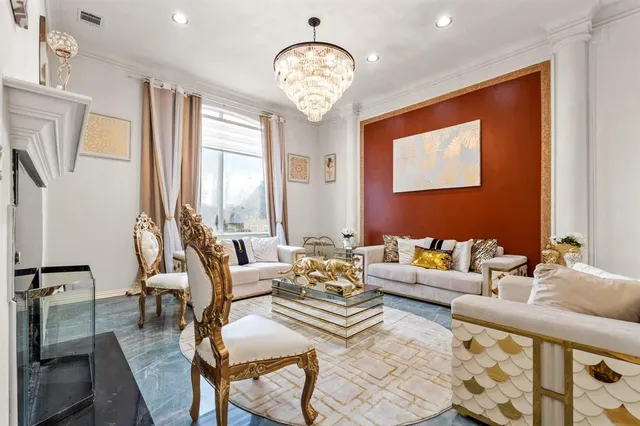 a living room with furniture a large window and a chandelier