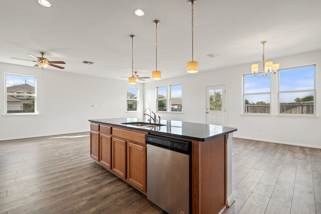 117 Wapiti Road Buda, TX 78610 - Photo 33 of 35 a kitchen with stainless steel appliances granite countertop wooden floors and sink