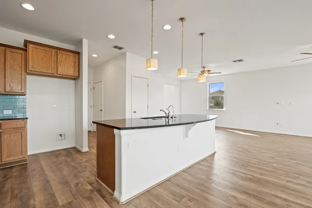a kitchen with stainless steel appliances granite countertop wooden floors and sink