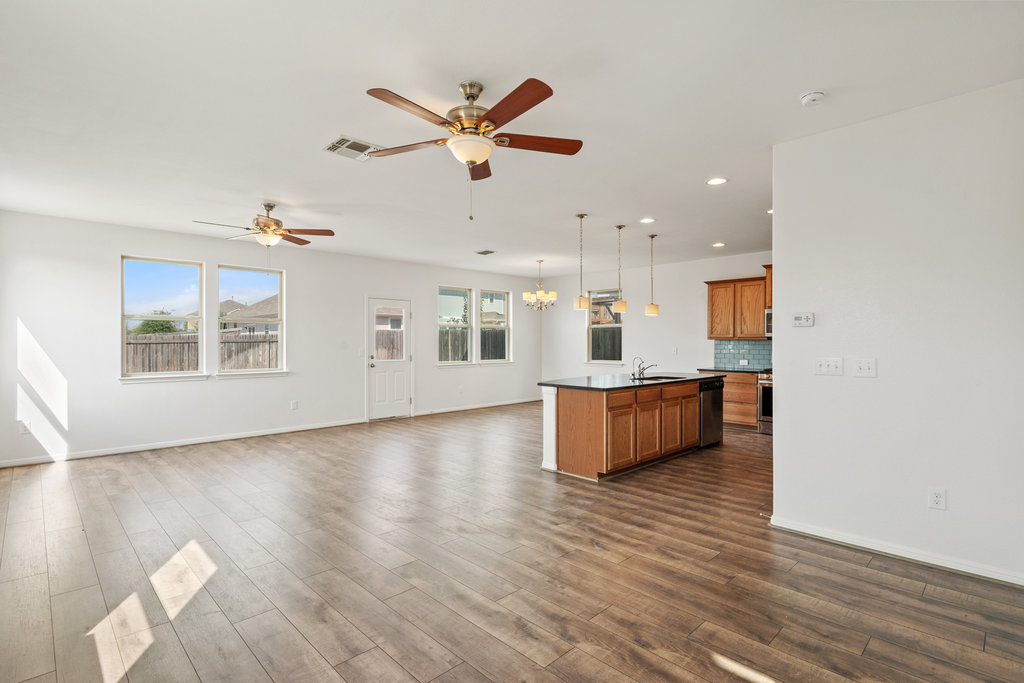 117 Wapiti Road Buda, TX 78610 - Photo 34 of 35 a large kitchen with stainless steel appliances kitchen island a large counter top and a wooden floors