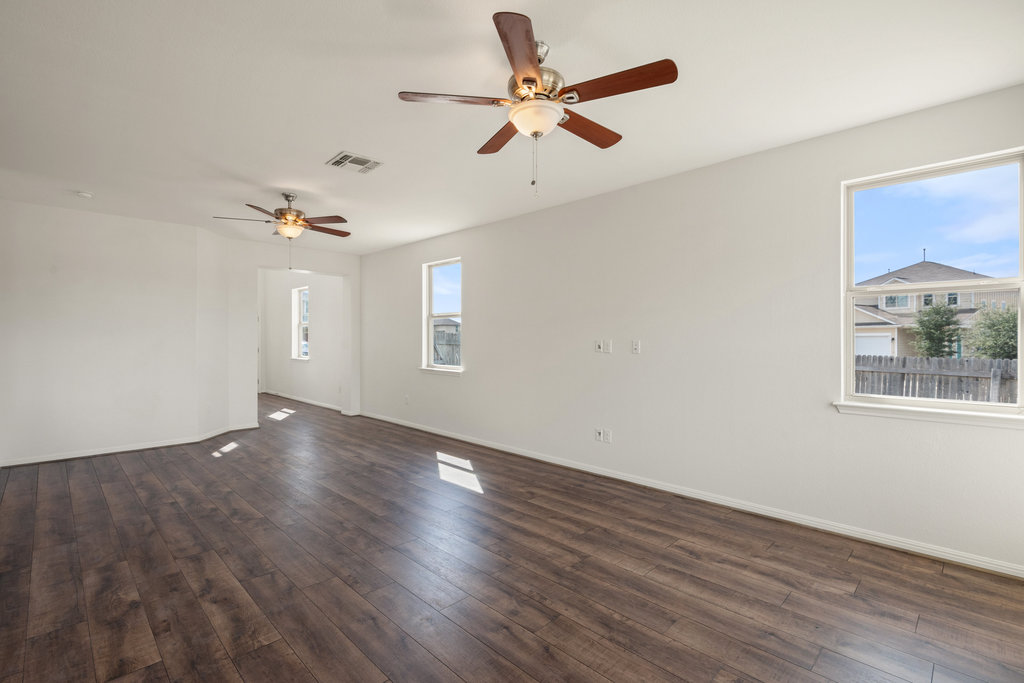 117 Wapiti Road Buda, TX 78610 - Photo 15 of 35 a view of an empty room with a window and wooden floor
