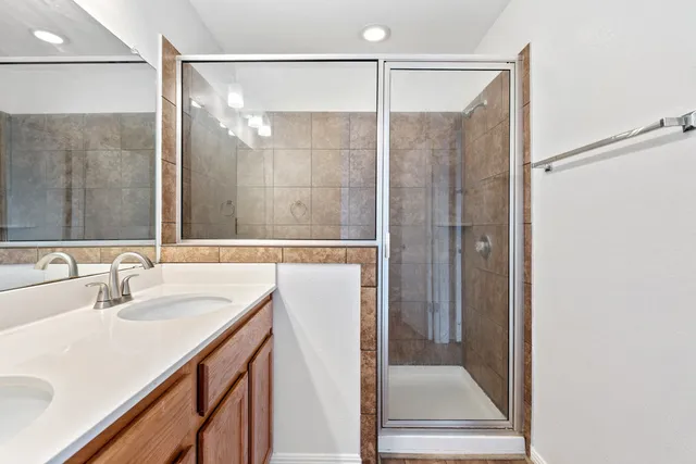 an empty room with wooden floor chandelier fan and windows