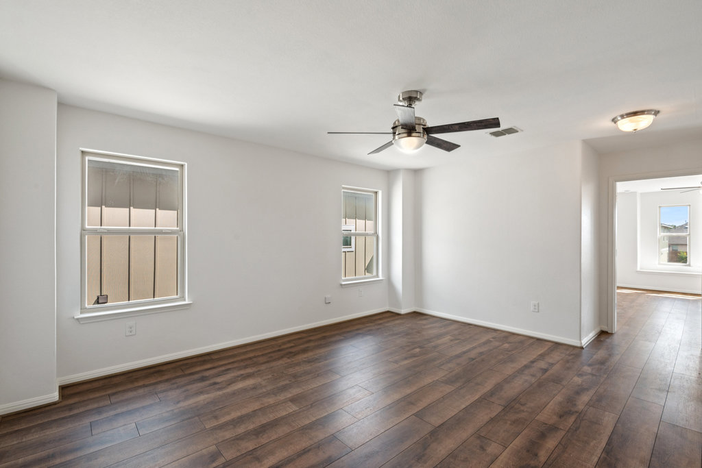 117 Wapiti Road Buda, TX 78610 - Photo 24 of 35 a view of wooden floor and a chandelier fan in a room