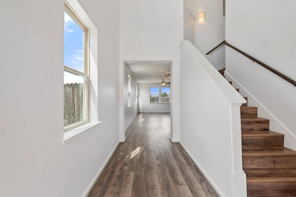 117 Wapiti Road Buda, TX 78610 - Photo 7 of 35 a view of a hallway with wooden floor and staircase