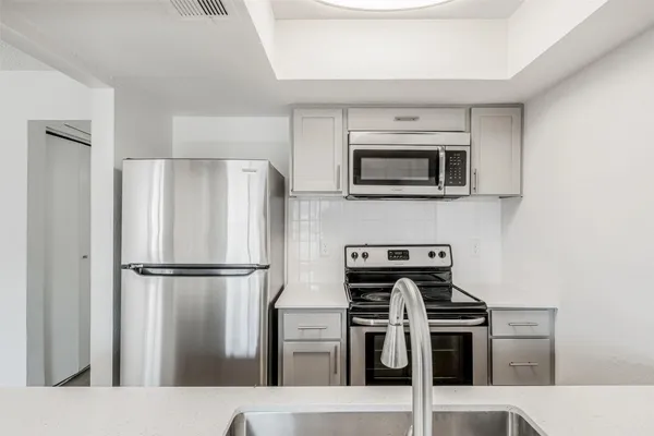 a kitchen with a refrigerator and a stove top oven