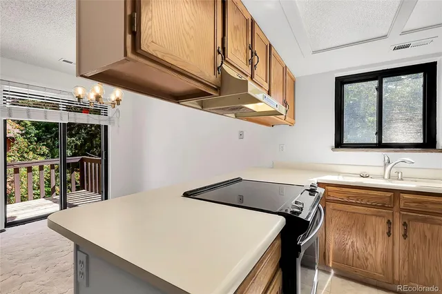 a utility room with stainless steel appliances a sink cabinets and a window