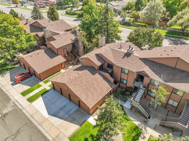 an aerial view of residential houses with outdoor space and trees
