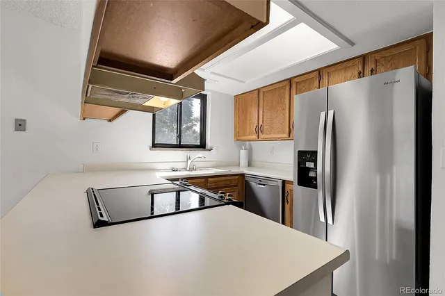 a kitchen with stainless steel appliances a refrigerator sink and stove