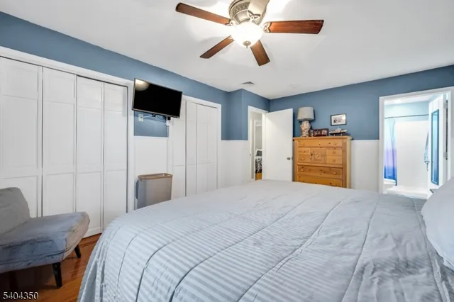 a bedroom with a large bed a flat tv screen and dresser