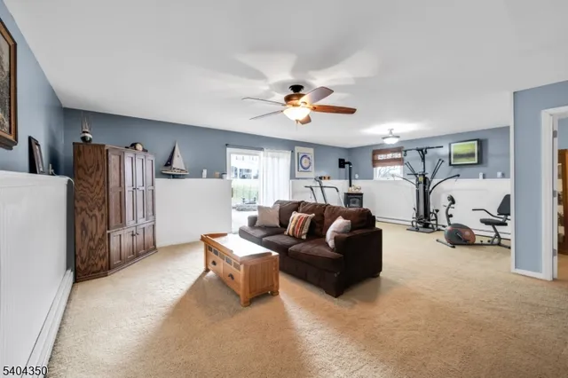 a living room with furniture a ceiling fan and a window